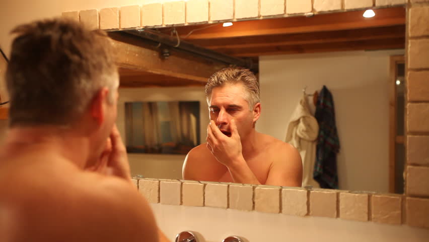 man waking up looking in mirror