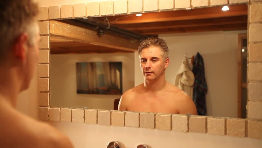 man waking up looking in mirror