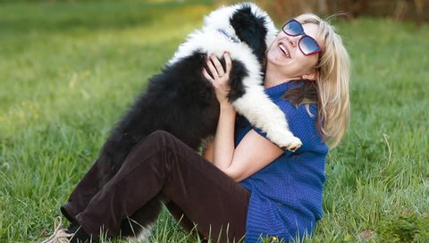 girl hugging a puppy bobtail in the park