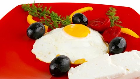 fried scrambled eggs eye with white goat feta cheese on red plate with black olives and vegetables 1920x1080 intro motion slow hidef hd