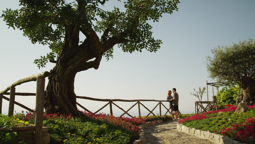 Wide Shot Pan Couple kissing, standing by balustrade / Ravello, Campania, Italy