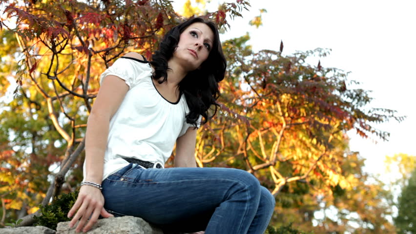 Girl sitting on brick ledge thinking