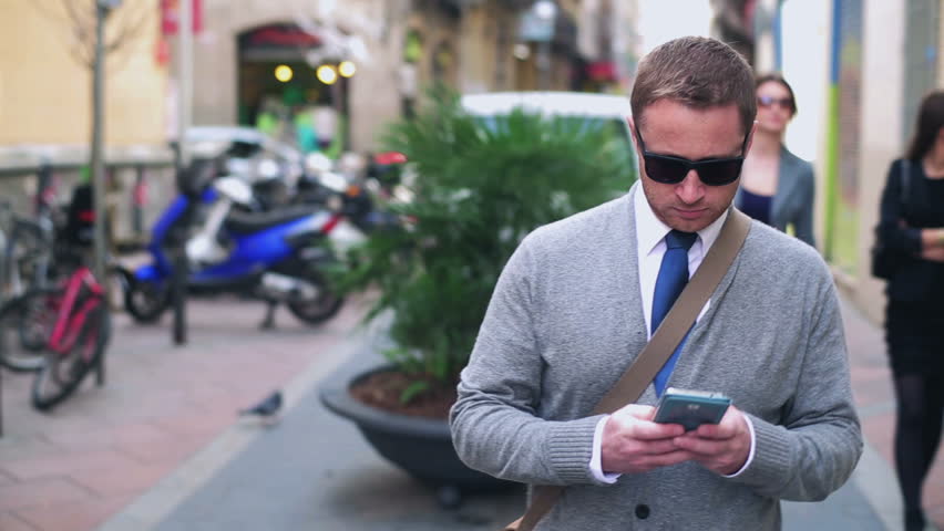 Man walking down the street and using cellphone, steadycam shot
 Royalty-Free Stock Footage #6397421