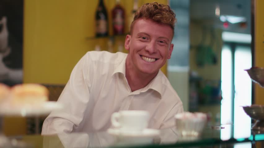 People, bar, cafeteria, portrait of happy young man working as barman, smiling at camera behind counter, serving cup of espresso coffee. 1of6 | Shutterstock HD Video #6398018