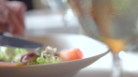 Person eating delicious salad in a restaurant. Young man enjoying dinner. Healthy food. Fresh vegetable salad. Close up. Slow motion video footage. Slowmo. Slow-mo. High speed camera shot