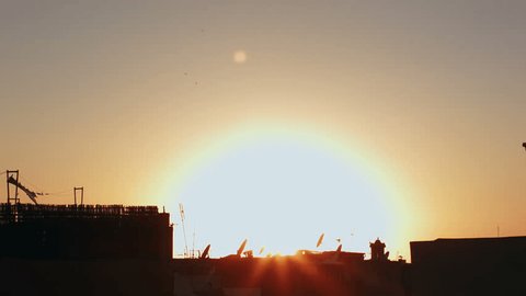 Sunset with houses and antennas in the foreground, Morocco, timelapse