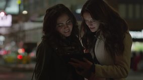 Close up of friends using digital tablet on urban street at night  - Powered by Shutterstock - Get 15% off with code: PIKWIZARD15