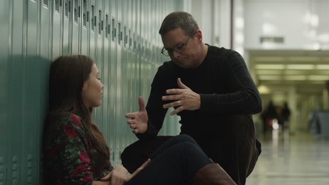 Teacher talking with teenage girl (14-15) at school