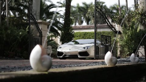 Cinematic Lamborghini driving through mansion gates slider shot 