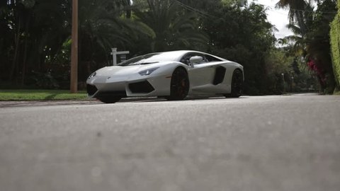 Cinematic Lamborghini driving through residential neighborhood slider shot