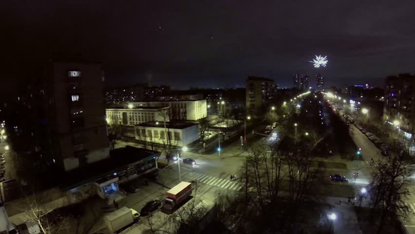 Cityscape with crossroad traffic and fireworks at night. Aerial view