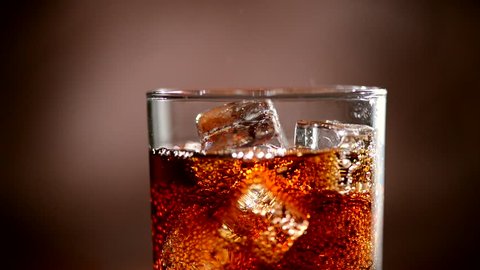 Cola with Ice and bubbles in glass. Cola pouring. Stock full HD video footage 1920x1080p