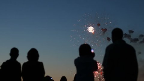 Blurred silhouettes of people watching fireworks : vidéo de stock