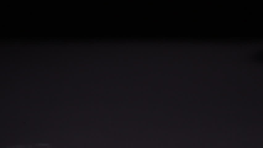 Pineapple falling and splitting on black background in slow motion