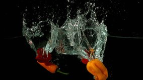 Chili peppers falling in water on black background in slow motion - Powered by Shutterstock - Get 15% off with code: PIKWIZARD15