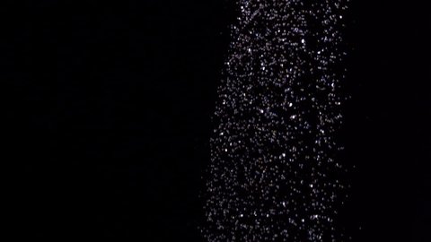 Water raining against black background in slow motion