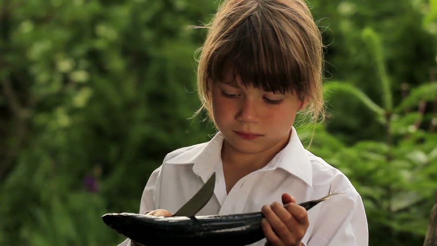 Boy holding a marine fish.Child preparing fish.Little cook.Boy holding a mackerel (portrait)

