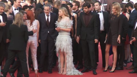 CANNES, FRANCE - MAY 2014: Kristin Stewart wearing a silver Chanel Couture ensemble with Chloe Grace Moretz, wearing a Chanel Couture gown with a high-low hemline and feather accents
