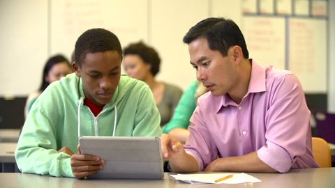 Male High School Student With Teacher Using Digital Tablet