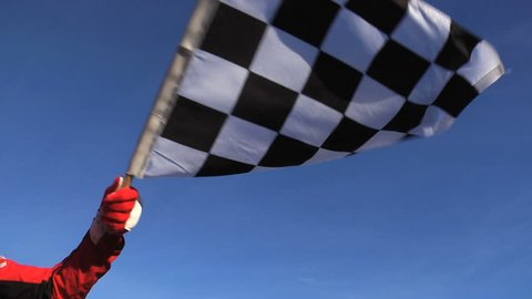 Race official waving checkered flag. Shot at full speed.