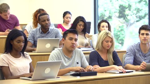 Students Using Laptops And Digital Tablets In Lecture