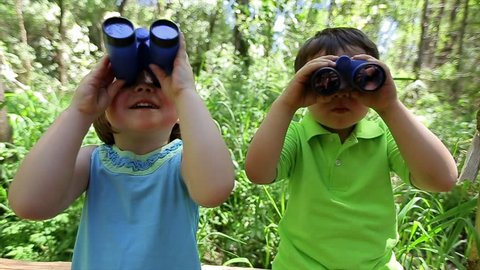 Kids Use Binoculars To Explore The Forest Around Them