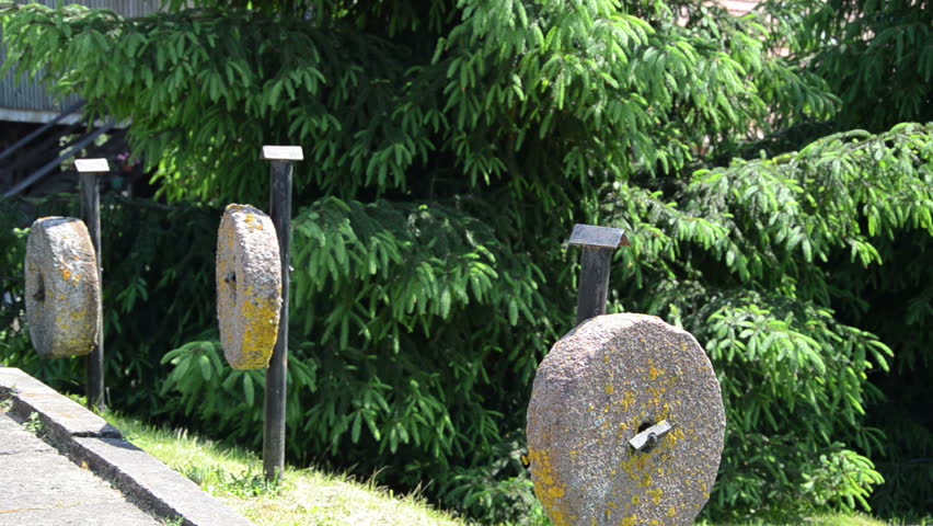 on three pillars coupled hard cement ancient millstones along swings trees