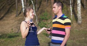 Young couple talking while drinking wine outdoors. Ultra HD 4K video