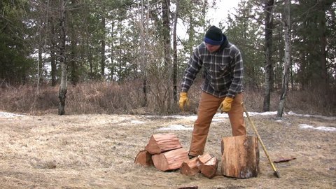 Man splitting wood with a maul