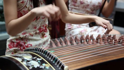 Chinese traditional musician playing chinese guzheng.Guzheng, also called zheng or Chinese plucked zither,is a plucked half-tube zither with movable bridges and strings