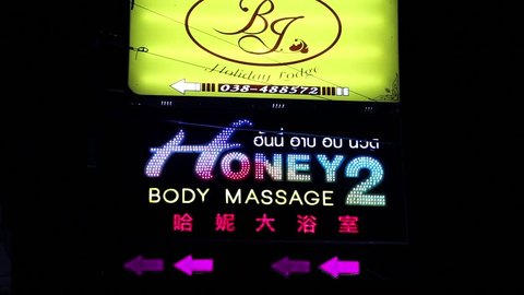 THAILAND, PATTAYA, MARCH 31, 2014: Body massage neon signboard in red-light district with many restaurants, go-go bars and brothels, Pattaya, Thailand