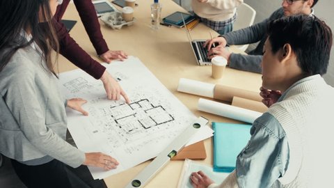 Woman architect showing plans to startup business team
