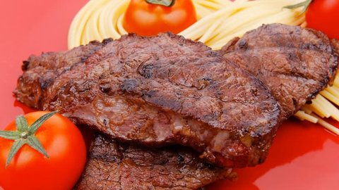 meat grilled beef steak with pasta and tomatoes on red plate 1920x1080 intro motion slow hidef hd
