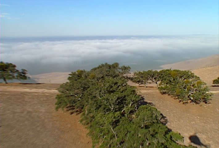 A low-flying aerial shot over foggy hills of California