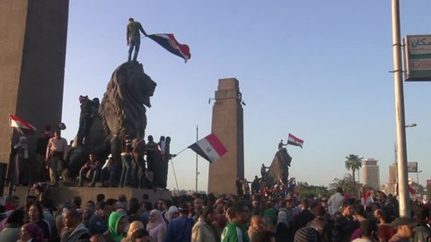 Large crowd assembles on Cairo side of Qasr al-Nil Bridge to march in to Tahrir Square for 1st Anniversary of Egyptian Revolution. Near Arab League HQ, bank of Nile River. Waving flags. 25 Jan 2012