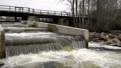 A fish ladder with rushing water found underneath a bridge