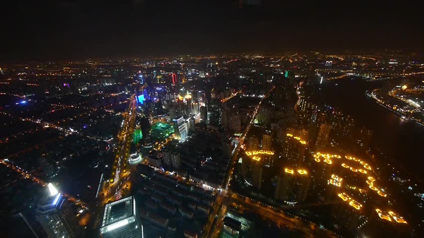 Elevated view of brightly lit high-rise buildings with river at night in Shanghai,China.busy shipping & urban traffic,time lapse,timelapse.  gh2_07673