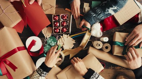 Hands wrapping Christmas presents arial view group of young diverse people, videoclip de stoc