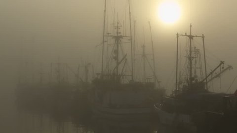 Morning Fog, Steveston Marina. The sun tries to burn through the fog that surrounds fishboats tied to the dock in Steveston Harbor near Vancouver. British Columbia, Canada.