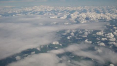 Looking down over clouds from a plane on a beautiful June day in London, 2014