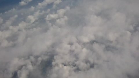 Looking down over clouds from a plane on a beautiful June day in London, 2014