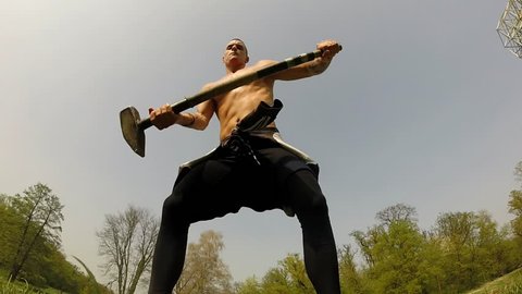 Close up of a strong man hitting with a hammer