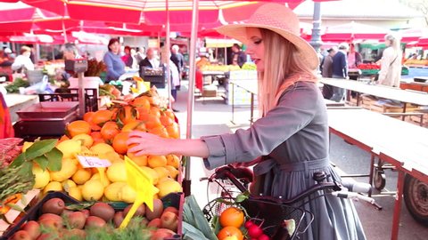 Beautiful girl at the market paying for fruit Stock Video