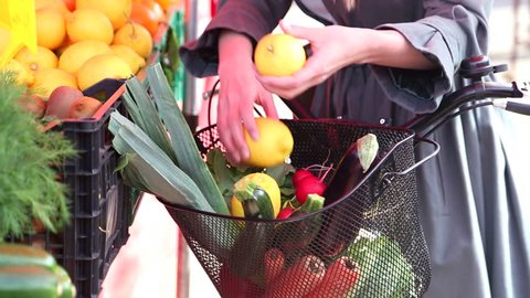 Close up of a bike with basket, full of fruit and vegetables