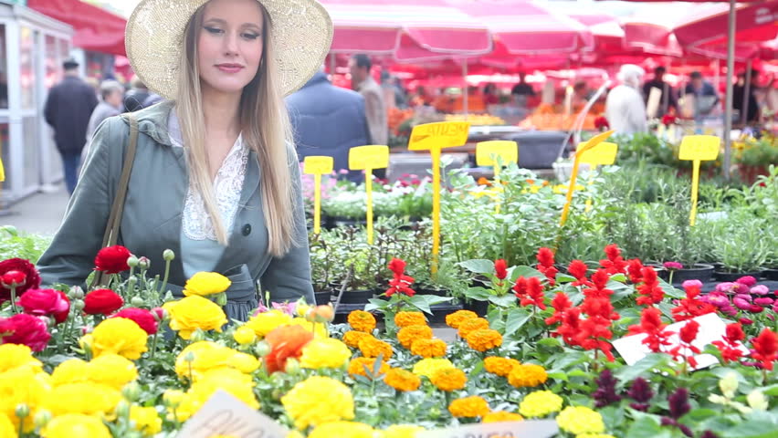 Pretty blonde woman in the flower market, talking