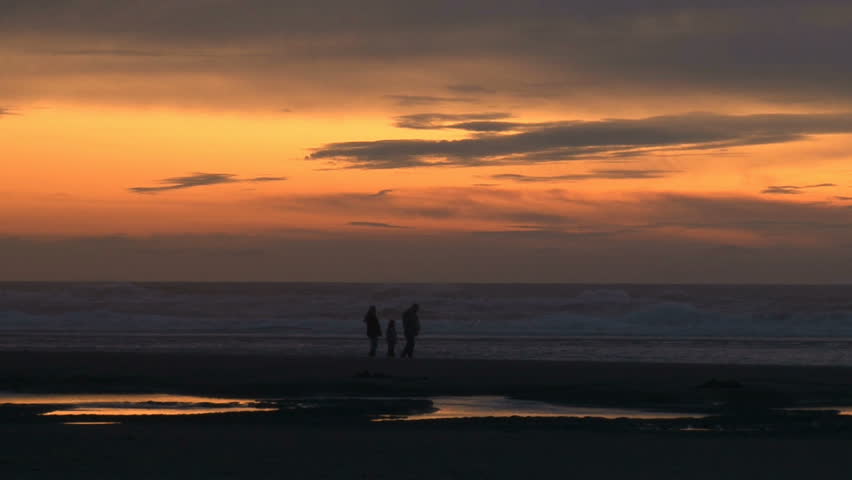 Family enjoys sunset at the ocean.