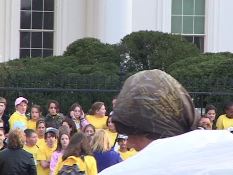 Zooms in on Conchita, who has been part of a 24 hour vigil in front of the White House since 1981, protesting nuclear weapons. White House in Background.