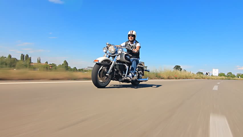 man riding his motorcycle  on a highway follow shot car point of view