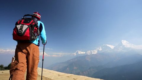 Trekker enjoying beautiful view of Annapurna and Dhaulagiri range from Poon hill, Nepal.  Poon hill is a part of Annapurna Sanctuary trek, one of the most popular adventure circuit trek in the world.
