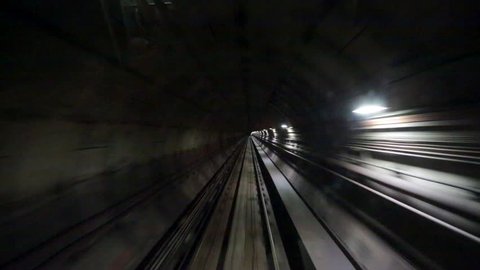 View of a subway tunnel as seen from the front of a moving train.
